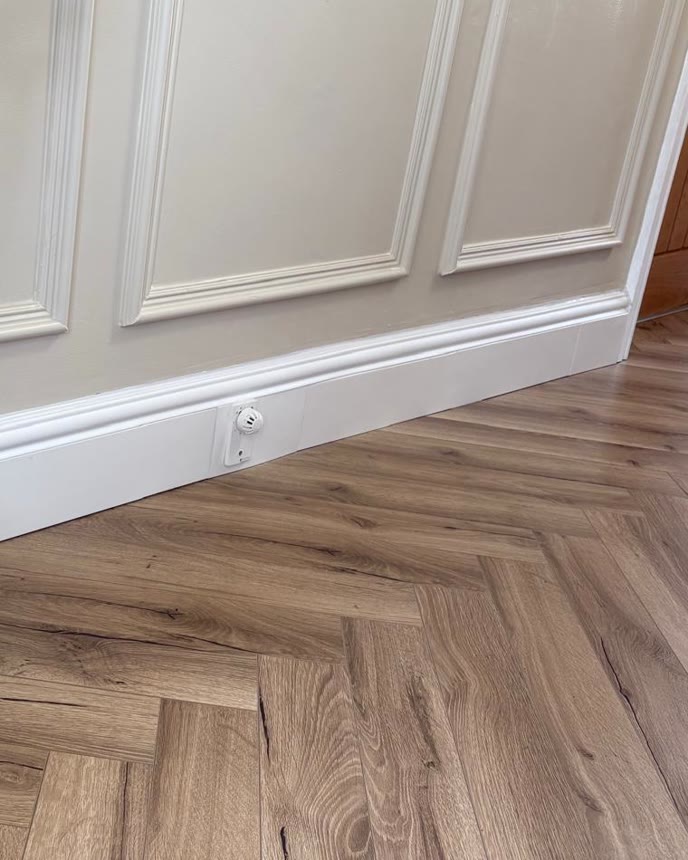 ThermaSkirt heated skirting fitted below panelled walls on a herringbone floor