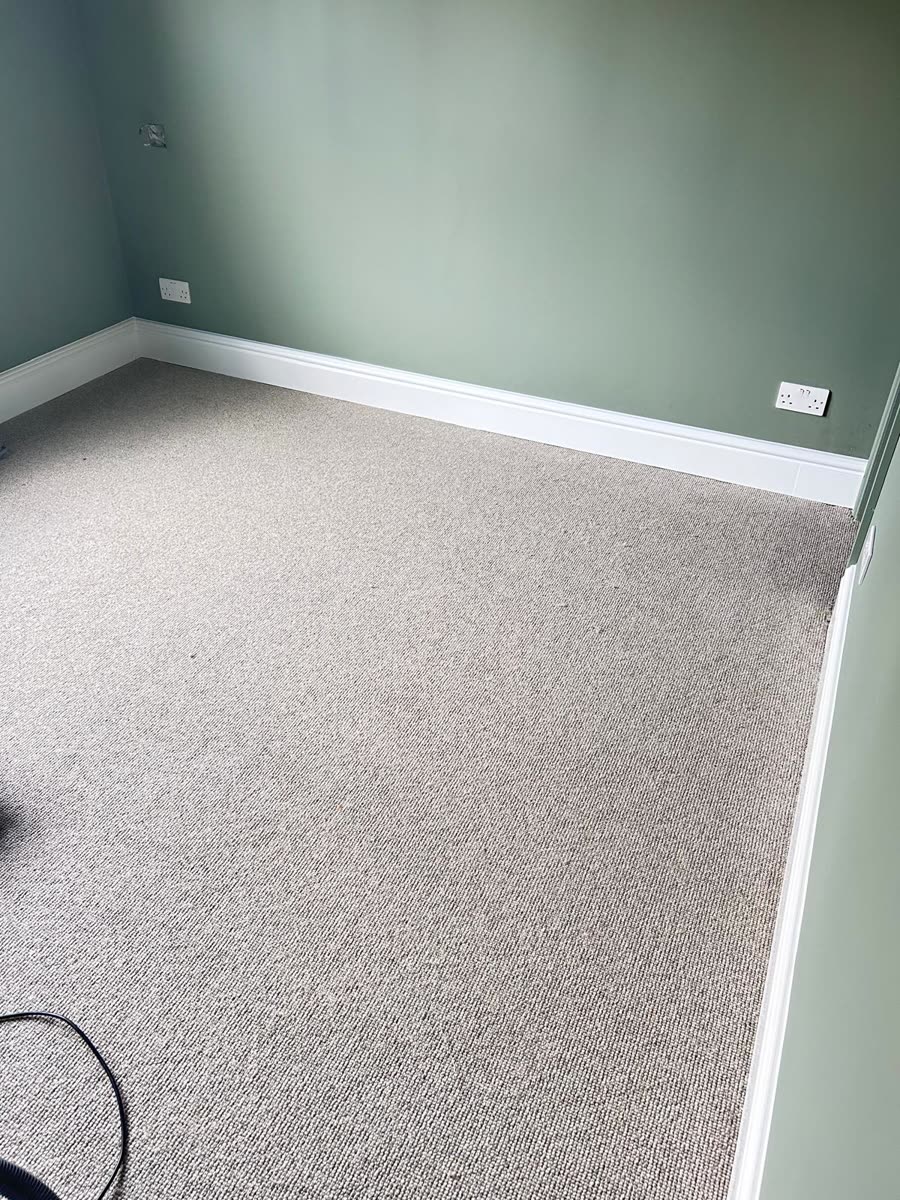 ThermaSkirt on a sage-green wall above a grey carpet