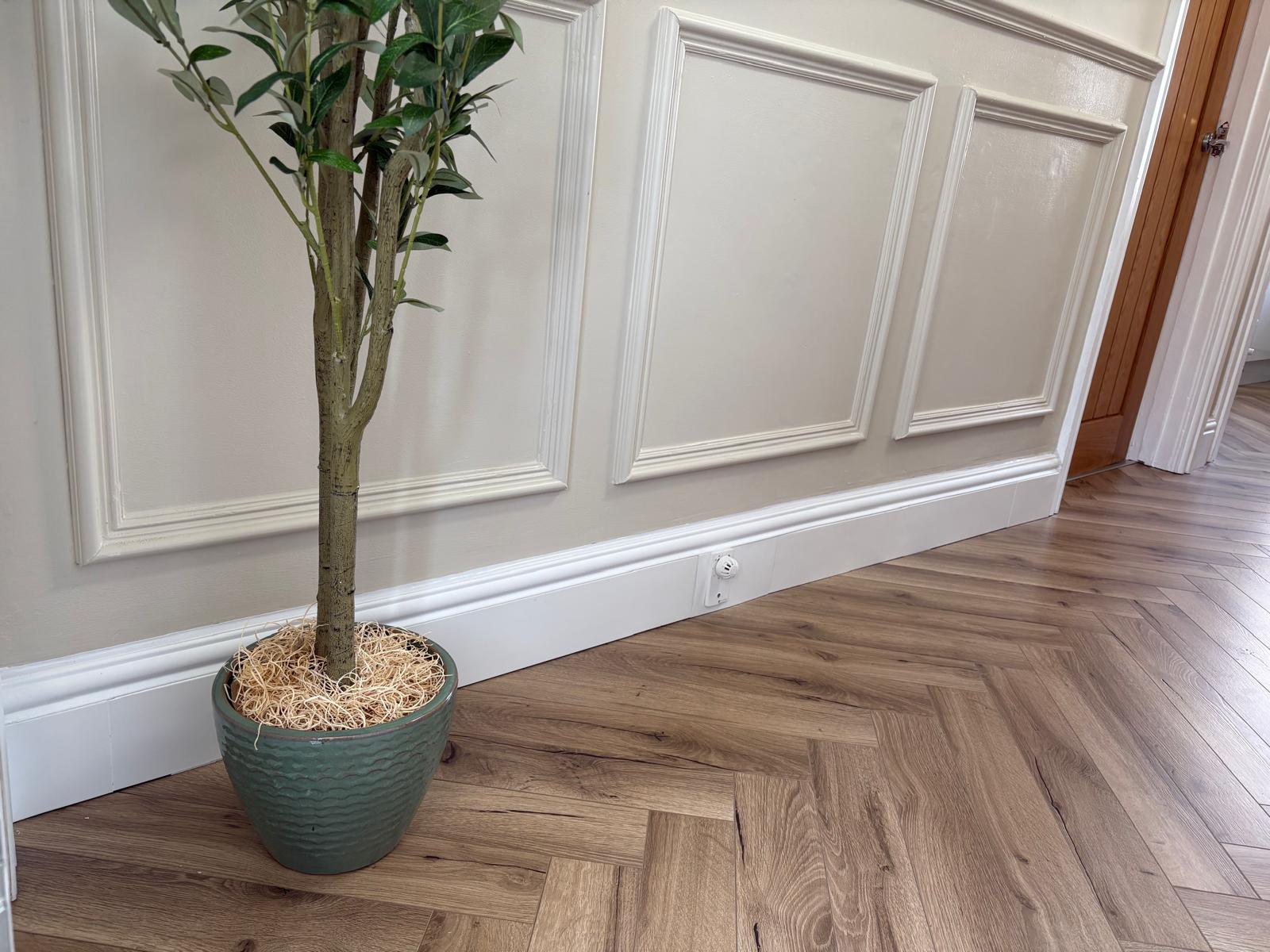 ThermaSkirt fitted along a panelled hallway with herringbone flooring — the skirting board is the heating